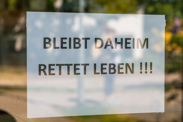 Fototapeta premium a closed shop with the german text stay at home. saves lives