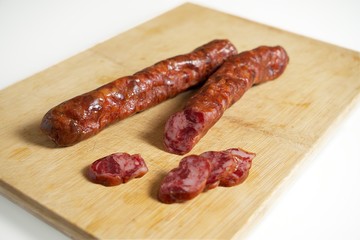 Smoked sausage on a wooden board, pork sausage, Bavarian specialty.