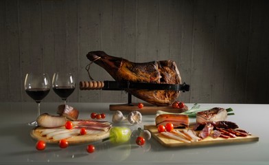 Table with pork meat delicacies, prosciutto, lard, sausage, Bavarian sausages, assorted vegetables