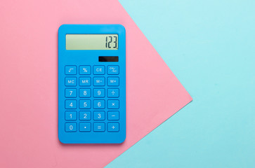 Blue calculator on pink blue pastel background. Calculation or counting. Copy space. Minimalism. Top view