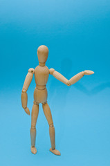 Wooden dummy proudly presents some invisible thing, isolated on white background, copy space for your object or text