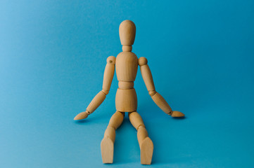 Wooden mannequin with empty miniature shopping cart running for sales on red background. Mockup for shopping, sales, black friday, copy space, side view.