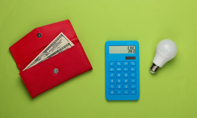 Calculation of the cost of medical expenses. Calculator and pills bottle, wallet with money on green background. Top view. Minimalism