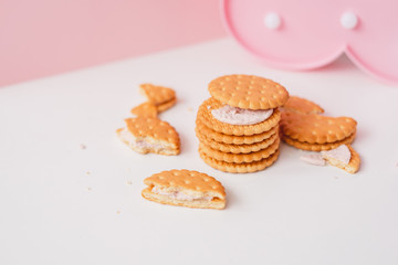 Sweet creamy filling crackers on a white-pink pastel background. 