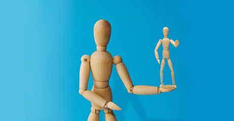 Wooden mannequin with empty miniature shopping cart running for sales on red background. Mockup for shopping, sales, black friday, copy space, side view.