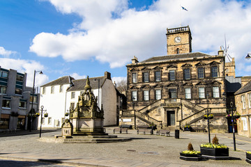 Linlithgow, Scotland, the small square known as The Cross.  The large building is Linlithgow Burgh Halls, which dates to 1670 and houses an art gallery, cafe and function rooms. 