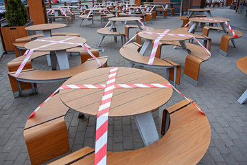 Outdoor cafe/restaurant is closed for quarantine during coronavirus epidemic. Access to restaurant, cafe is prohibited for duration of pandemic, seats are blocked with a warning tape