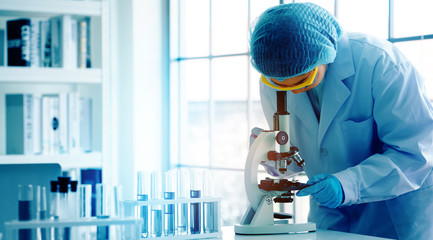 Asian scientist or doctors use microscopes to test for the coronavirus (COVID 19). Or a new flu...
