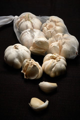 Bulbil, head and net of garlic on a dark background
