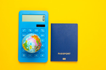 Traveling background. Calculation of the cost of travel around the world. Calculator, globe with a passport on a yellow background. Top view