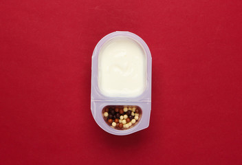Quen in a plated box with chocolate corn balls on red background. Top view. Minimalism food concept.
