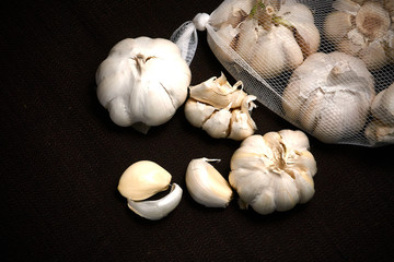 Bulbil, head and net of garlic on a dark background