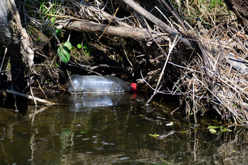 Illegal entsorgte Flasche in einem Fluß