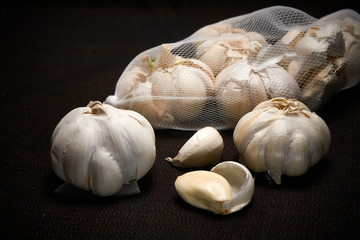 Bulbil, head and net of garlic on a dark background