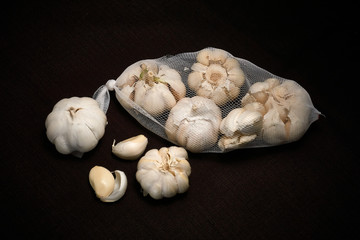 Bulbil, head and net of garlic on a dark background
