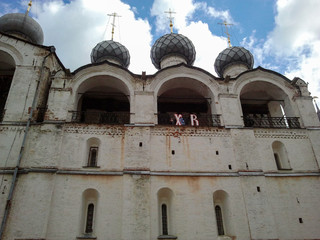 Fototapeta na wymiar Orthodox church with domes and a white wall. Rostov Kremlin
