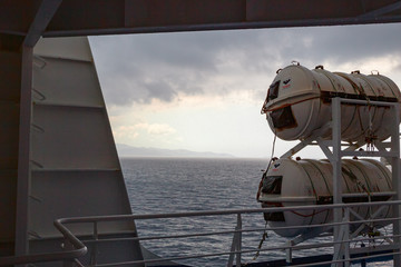 Lifeboats of a ferryboat sailing during a thunderstorm.