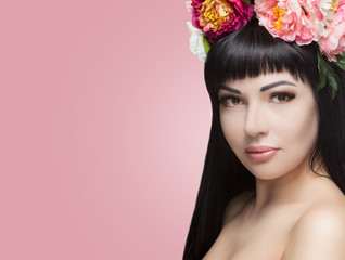 Naklejka premium Portrait of a beautiful happy woman with beautiful long hair and makeup. She has a wreath of flowers on her head. Cosmetology skin care and makeup.