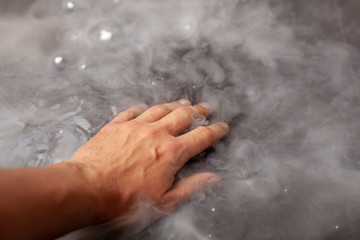 Fototapeta premium Thick white smoke on a background of black ceramic tiles.