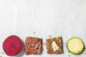 Fototapeta na wymiar Close up flat lay top view crunchy flax seed crispbread with dry and raw vegetables on white background copy space