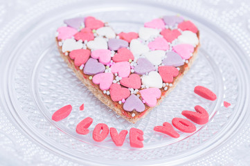 A gingerbread heart made from a variety of candies