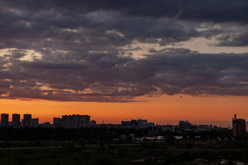 Sunset over the city. Sunset sky with beautiful clouds