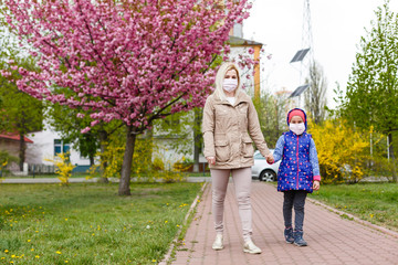 Obraz premium Mother and daughter with masks walking and talking on the street