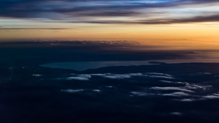 Lake Balaton from an aerial view, with soft clouds, yellow sunset, and distant Hungarian lands, cities. 