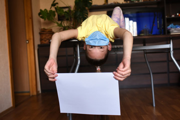 senior woman doing yoga exercise. young woman holding blank sign. Coronavirus. Woman with face mask on quarantine, cooks in the kitchen at home during coronavirus crisis. Stay at home. Enjoy cooking a