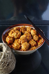 very spicy meatball in a bowl with chopsticks for snacks or lunch in dark background