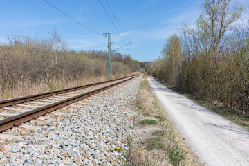 Fototapeta na wymiar Straight view along a footpath and railway tracks