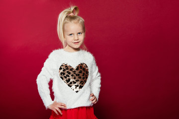 Close-up portrait of a girl, she has folded her hands and looks to the side. A smile and joy are on the face