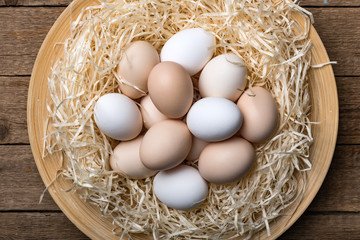 Organic chicken eggs in nest on wooden background. Food photography