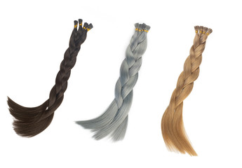 Set of multiple fake women hair extensions in tails, isolated on white background. Dark blonde, brown and silver color. and different attachment types.