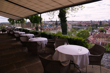 Tables for lunch in a restaurant on the background of the city of Prague
