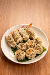 White Dish of Asian Steam  Dumplings  or Dim Sum a Famous Chinese Food  with Pork and Shrimp on  Wood Table.