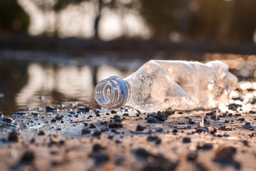 Waste from plastic bottle floating on the water in riverside of the swamp is a problem and water pollution close-up.
