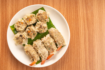 White Dish of Asian Steam  Dumplings  or Dim Sum a Famous Chinese Food  with Pork and Shrimp on  Wood Table.
