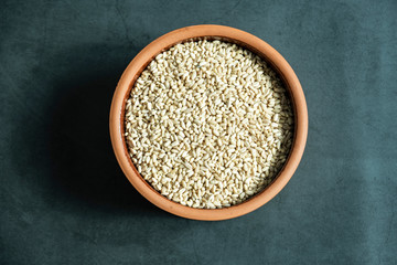 Wheat grain in pot bowl on concrete, stone background. Top view, flat lay.