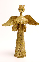 Adorno navideño ángel dorado sobre fondo blanco. 