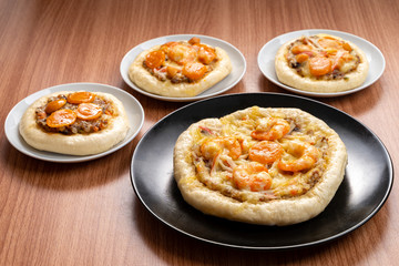 Pizza Cheese with Shrimp, Pork, Imitation Crab Stick and Salted Eggs on White Dish Wood Table.