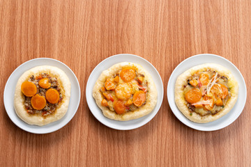 Pizza Cheese with Shrimp, Pork, Imitation Crab Stick and Salted Eggs on White Dish Wood Table.