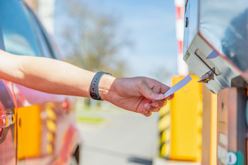 The man takes a parking ticket when entering the paid parking lot by car © edojob