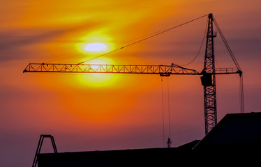 The construction crane on sunset. Construction crane at sunset, during the construction of a residential building.