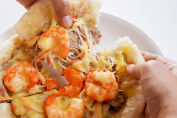 Closeup Hand Tearing Pizza Cheese with Shrimp, Pork, Imitation Crab Stick and Salted Eggs on White Dish Wood Table on White Background Isolated.