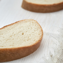 White bread sliced on white wooden table.