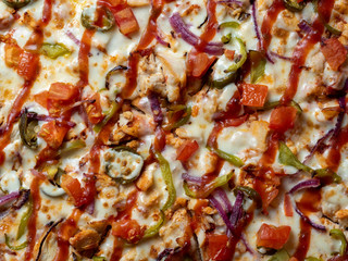 Delicious classic Mexican pizza with meat, peppers, onions, tomatoes, jalapeno and cheese close-up on top