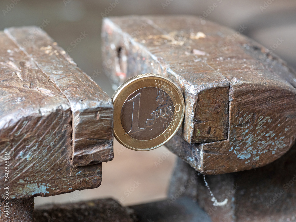 Wall mural A one-Euro coin without England, held in a metal vise. The concept of financial problems, brexit, the split of Europe