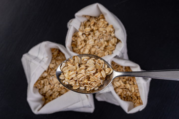 Oatmeal on a metal spoon. Healthy food best for breakfast.
