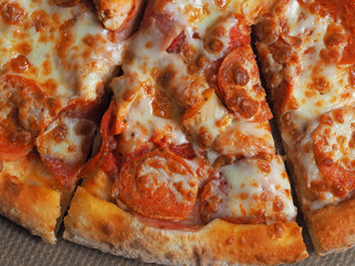 Closeup top view of pizza with ham, Perroni and cheese. Delicious Italian dish at home